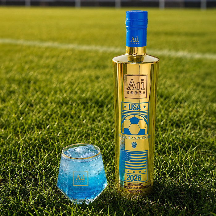 Au Vodka USA Gold bottle with a blue cap on green grass next to a blue drink