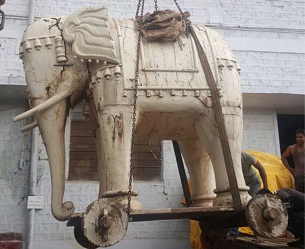 Large wooden elephant being transported