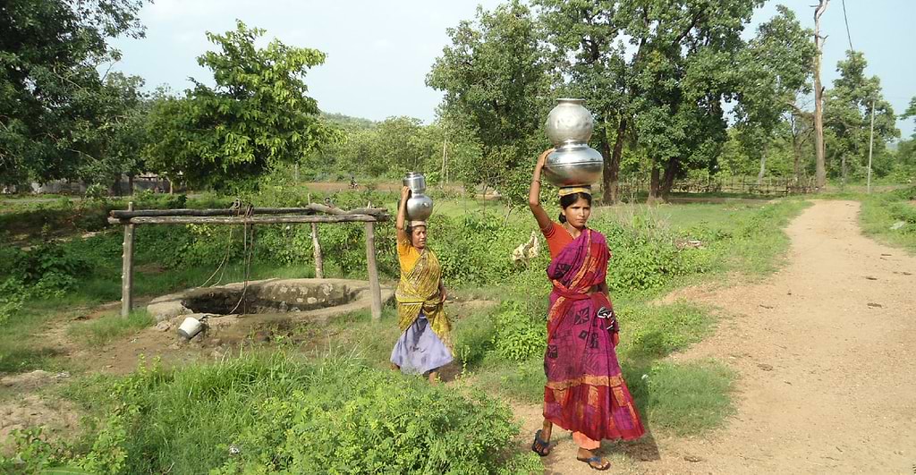 Indian landscape with woman carrying water on her head