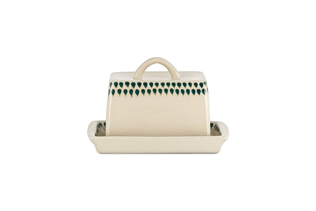 The nkuku Juniper Drop Butter Dish - Cream & Juniper is a rectangular ceramic dish with a handled lid and green drop detailing along the top edge, all set on a white background.