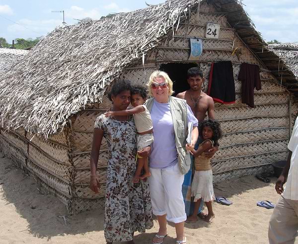 Indian family and Joy outside a traditional hut