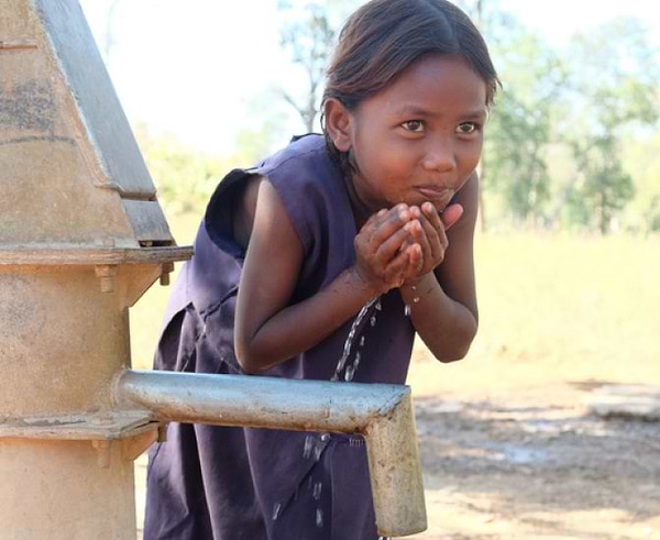Young Indian girl drinking water with hands