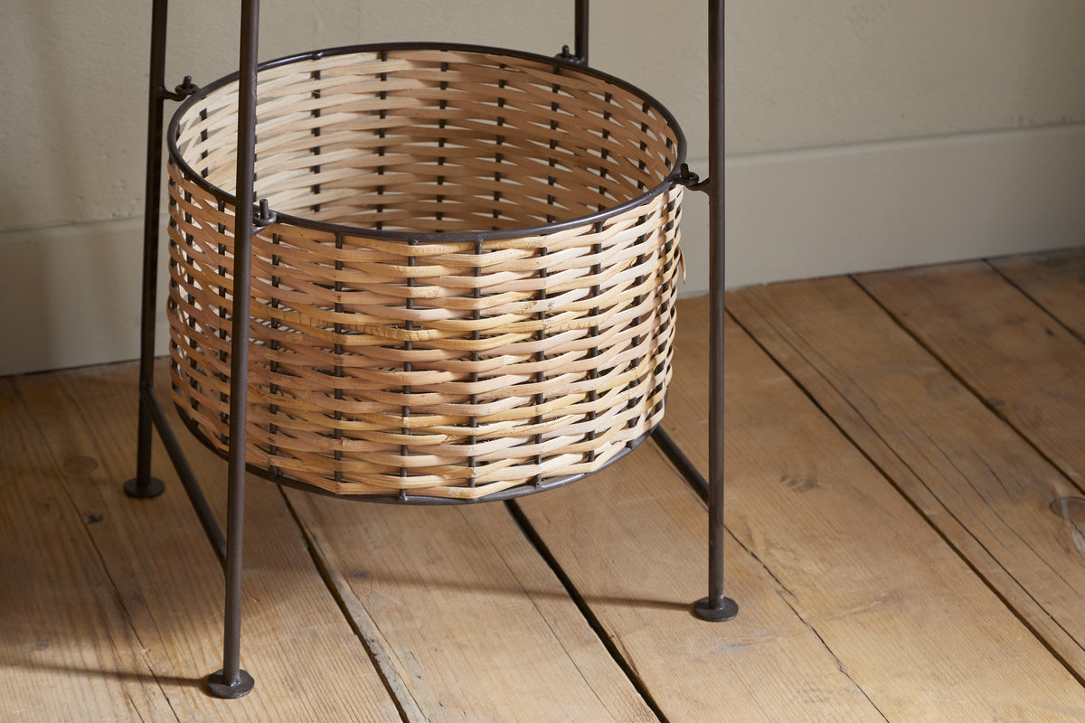 The Montali Iron & Rattan Three-Tiered Storage Stand by nkuku features handwoven natural rattan baskets with light and dark brown stripes on a black metal frame—perfect for stylish, practical kitchen or pantry organization.