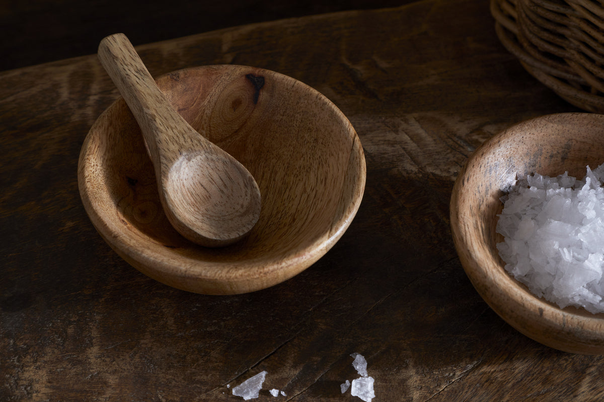 The nkuku Daruka Salt & Pepper Dipping Bowls with Spoons - Natural add charm to your table, featuring matching wooden bowls and spoons perfect for serving salt, pepper, or condiments.