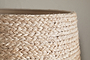 Close-up of the nkuku Pisang Natural Lampshade - Natural, showcasing its organic texture and tightly braided natural fibers. The plain background highlights the detailed craftsmanship and intricate weave.