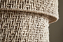Close-up of two rolled pieces of coarse, natural beige burlap, displaying a rustic, geometric weave like the Thimba Woven Jute Chandelier by nkuku, with interlaced fibers reminiscent of its handcrafted texture under natural light.