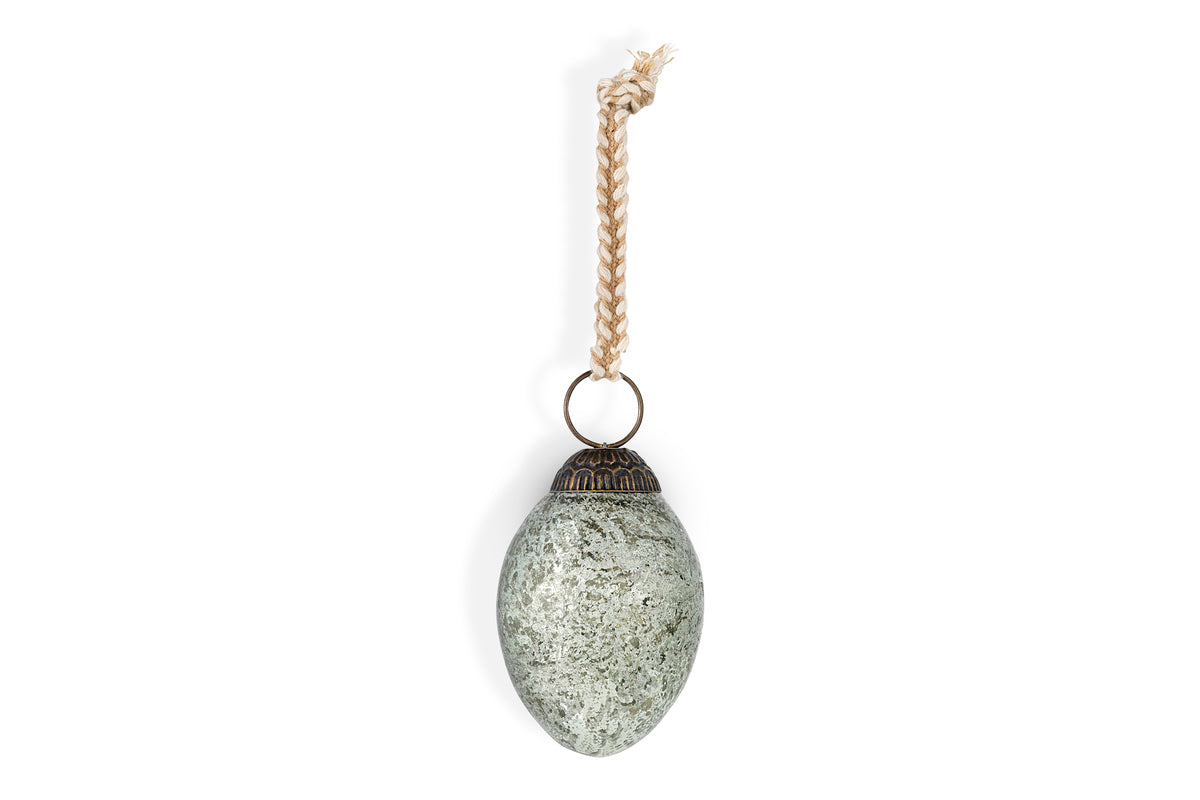 The Andai Hanging Egg Decoration by nkuku features an oval, mottled gray-green stone with an ornate dark metal cap and braided natural fiber cord. Sold as a set of 4 in antique teal, shown here against a plain white background.