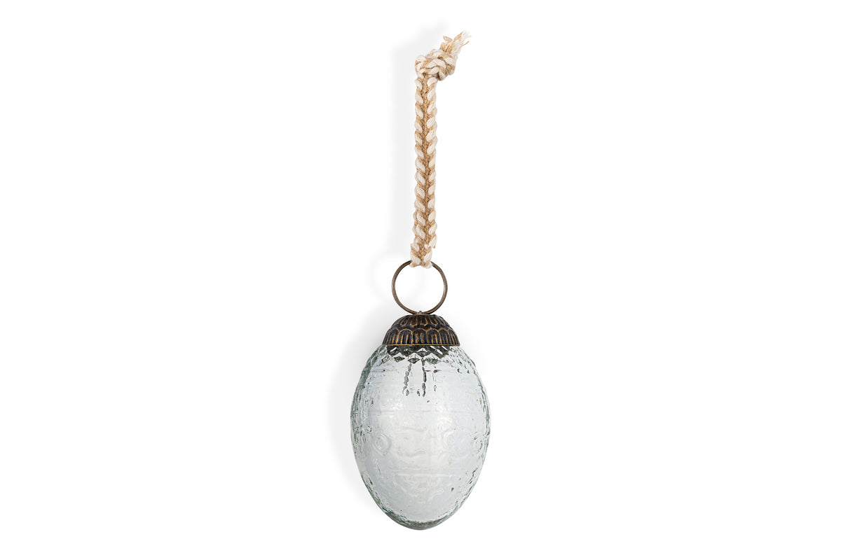 The nkuku Essan Hanging Egg Decoration - Clear (Set of 4) features oval, textured glass ornaments with antique-style metal caps and rope hangers, perfect for adding a subtle decorative touch against any backdrop.