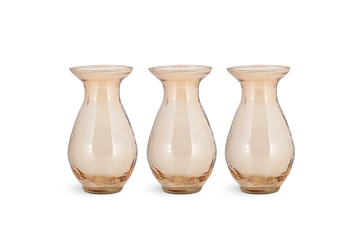 The Bapti Bud Vases by nkuku come as a set of 3 in dusty terracotta, each with a wide flared rim, rounded body, and narrow base. Arranged side by side on a white background, their surfaces have subtle texture for added charm.