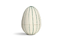 The nkuku Surya Recycled Cotton Paper Standing Opening Egg in teal and cream features a textured surface with vertical green lines. Made from recycled cotton paper, it brings charm to any Easter table setting.