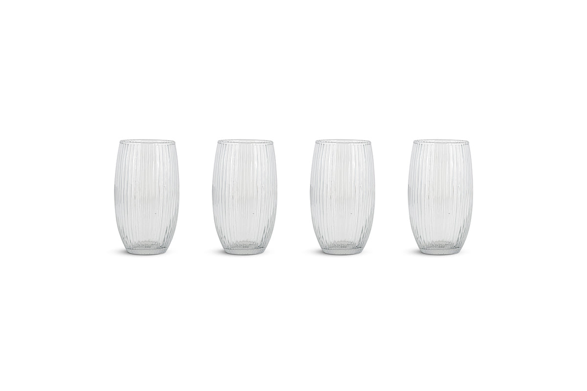 The nkuku Otuba Highball - Clear - (Set of 4) features tall glasses with a vertical ribbed texture, arranged side by side on a plain white background with subtle gray shadows beneath them.