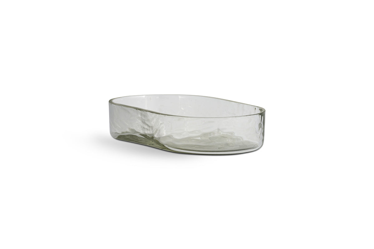 The Ilcoso Recycled Hammered Glass Soap Dish by nkuku features a clear, oval shape with textured sides and a smooth rim. Its subtle tint and handcrafted look make this unique recycled glass piece a stylish bathroom accessory.