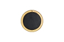 The Putali Etched Mirror - Antique Brass by nkuku is a sculptural wall mirror with a wide gold-toned rim adorned with subtle engravings, a rectangular top detail, and a solid black center, shown from above on a white background.