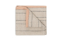 The Buna Table Runner - Clay by nkuku features natural stripes and a peach-toned border. Its folded design with a turned-up corner showcases both sides, making it a stylish addition to your dining table. Displayed on a plain white background.