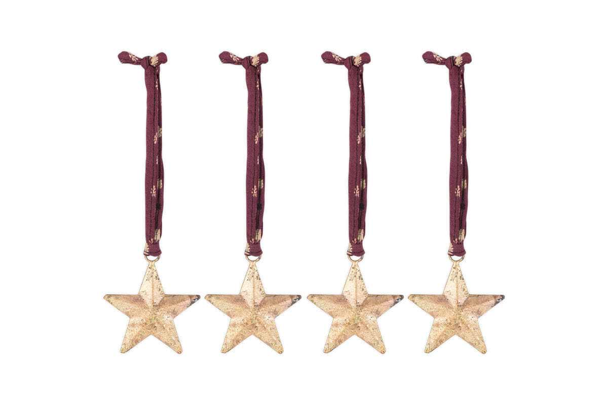 The Roshani Star Baubles - Antique Brass (Set of 4) by nkuku feature sleek gold star silhouettes with an antique brass finish and red string for hanging.