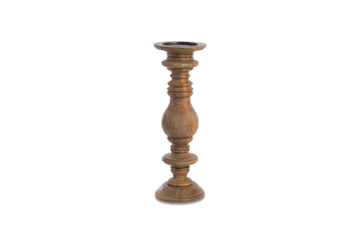 The Akello Candle Stick by nkuku is a tall, turned mango wood holder with a natural brown finish, curvy central column, carved details, rounded base, and flat top. Ideal for fireplace decor. Displayed against a plain white background.