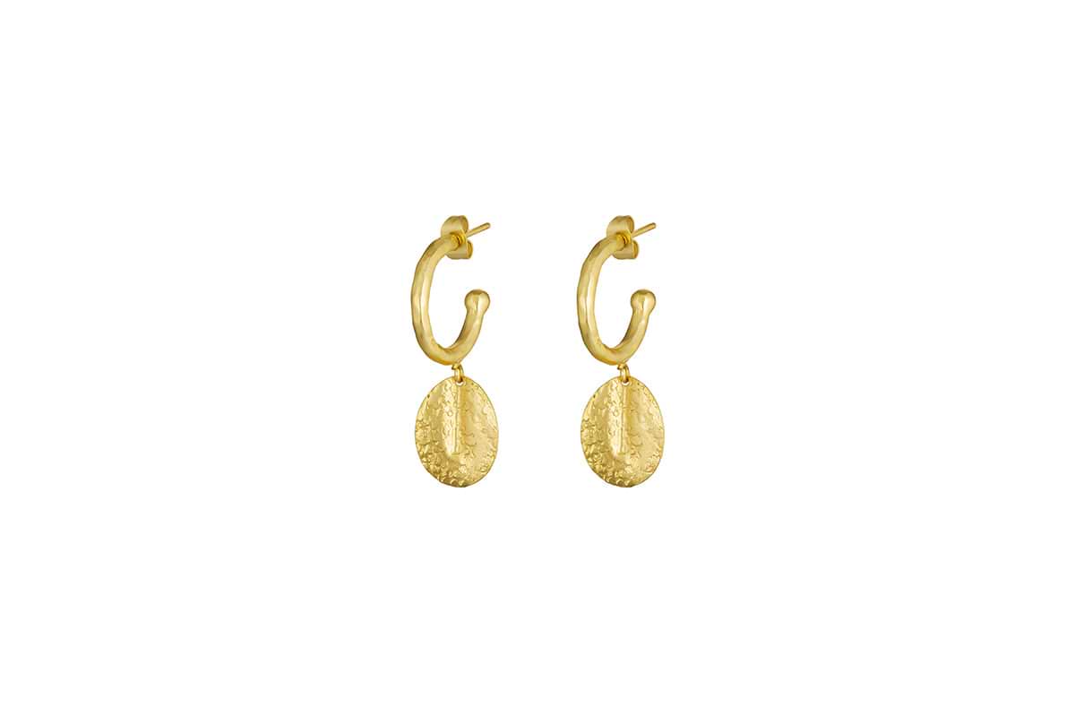 The Esta Hoop Earrings - Gold by nkuku feature textured, hammered oval pendants hanging from each shiny hoop, offering a simple and elegant handcrafted style. Shown in one size against a plain white background.