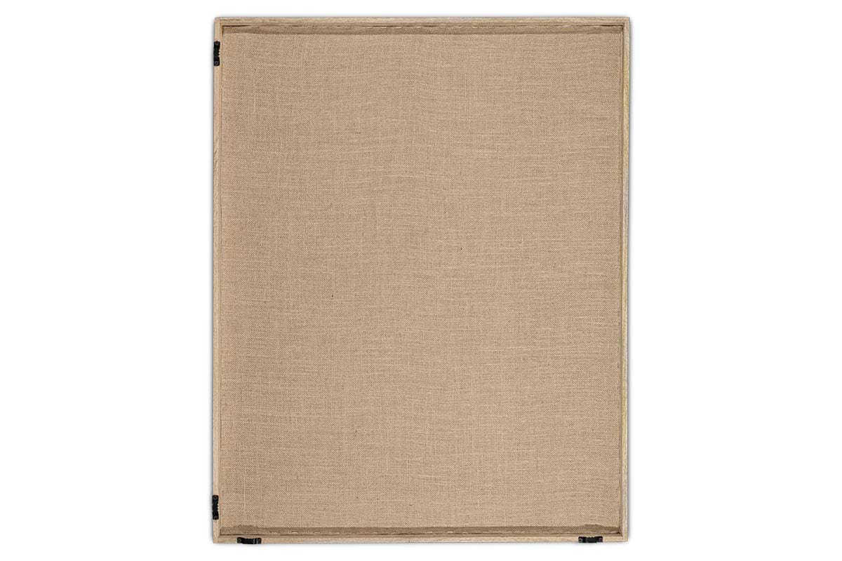 The Ikona Textured Wall Art - Natural by nkuku features a beige linen canvas stretched over a rectangular wooden frame. Black staples at the corners and smooth woven texture add subtle elegance, making it perfect as neutral wall decor.