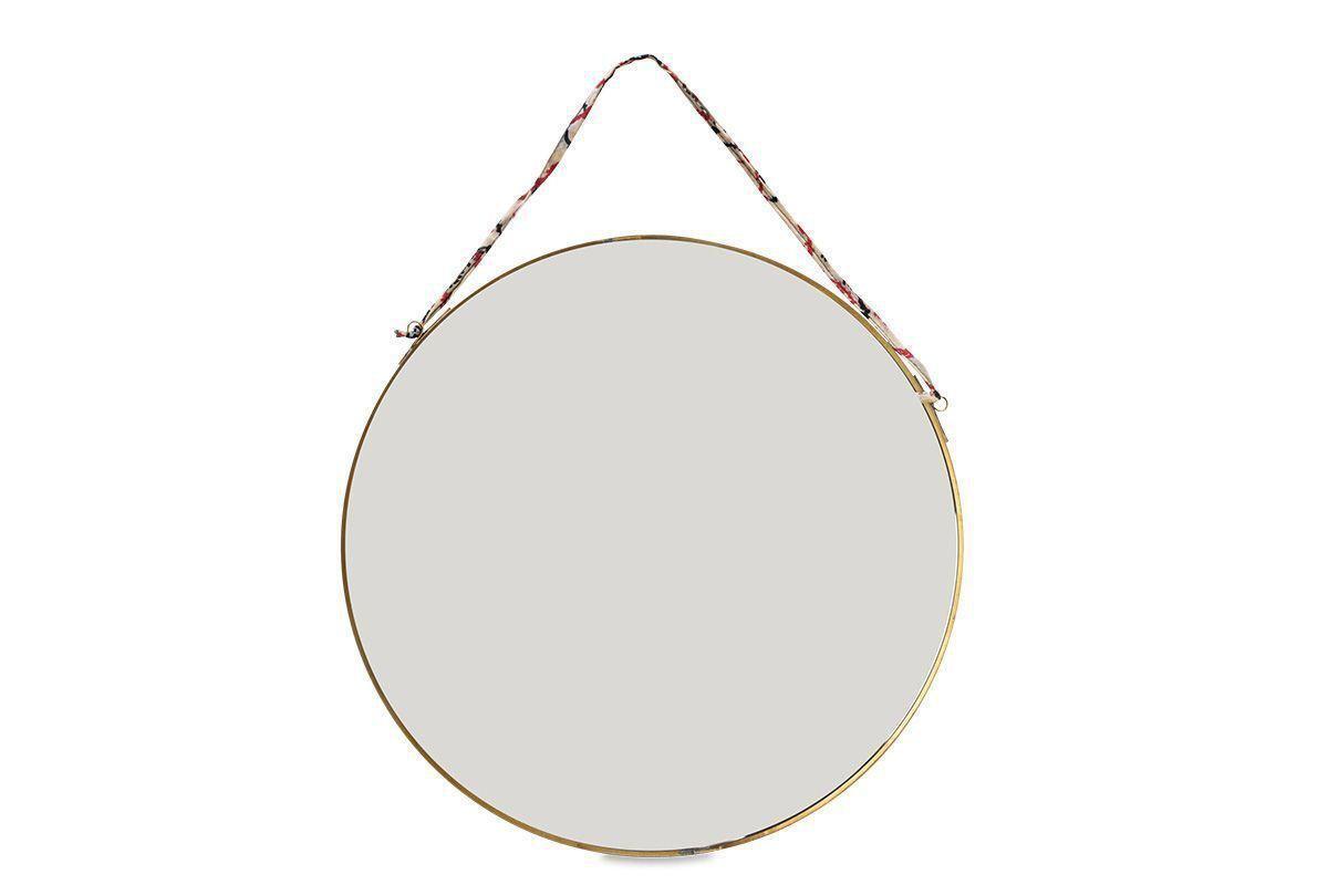 The nkuku Kiko Round Mirror - Brass features a slim antique brass frame and hangs from a colorful recycled sari tie, adding sustainable elegance to any space. Its modern design and blank reflection stand out against a white background.