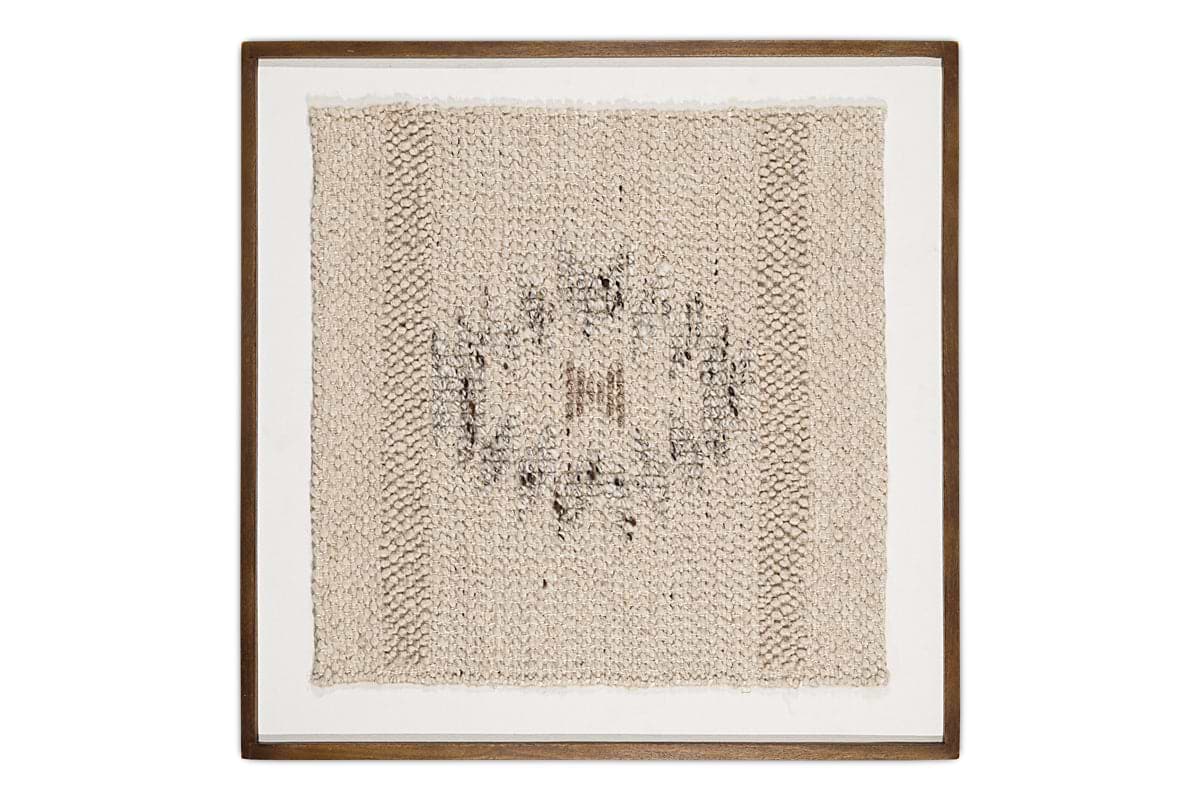 The Lena Textured Wall Art - Off White by nkuku features a square, open-knit beige fabric in a dark wood frame, showcasing an irregular circular pattern in darker thread on a white, subtly uneven background.