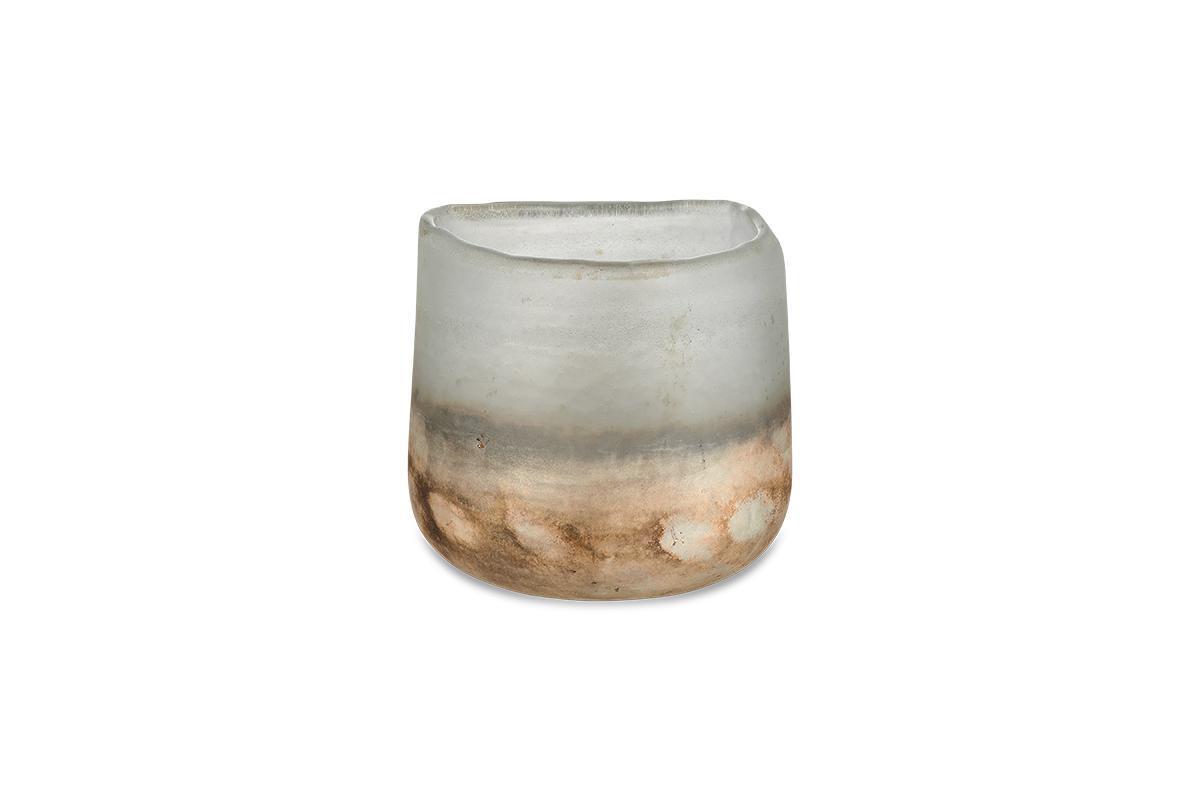 The nkuku Ngolo Tealight Holder - Aged Smoke is a small, cylindrical holder made from recycled glass. Its frosted surface fades from grayish-white to brown, and its irregular rim beautifully catches light against a white background.