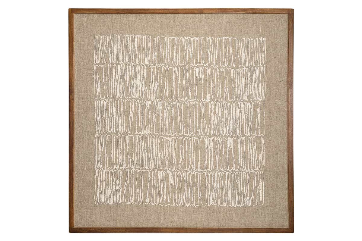 The Birala Hand Stitched Wall Art - Natural by nkuku features irregular vertical white stitching on textured beige fabric, framed in sustainable mango wood with a medium brown finish that enhances its neutral tones.