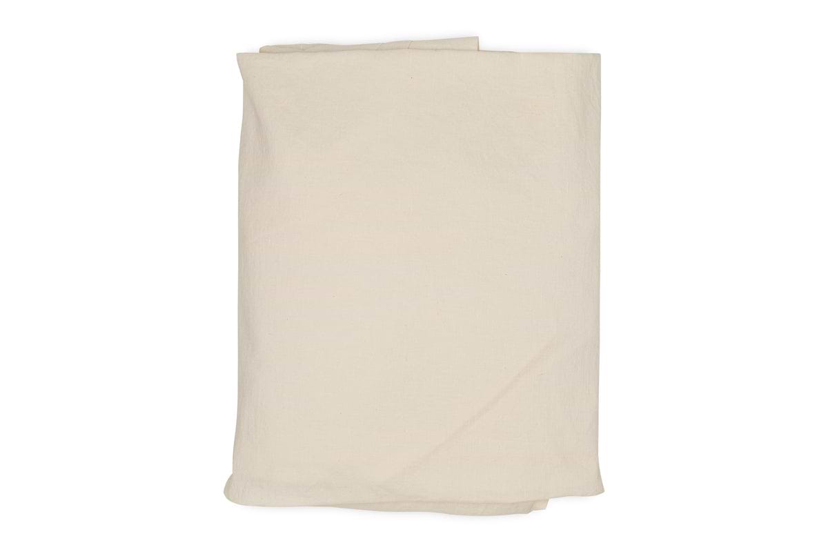 The Cela Hemp & Cotton Fitted Sheet - Natural by nkuku, in plain off-white, is neatly folded and displayed against a white background.
