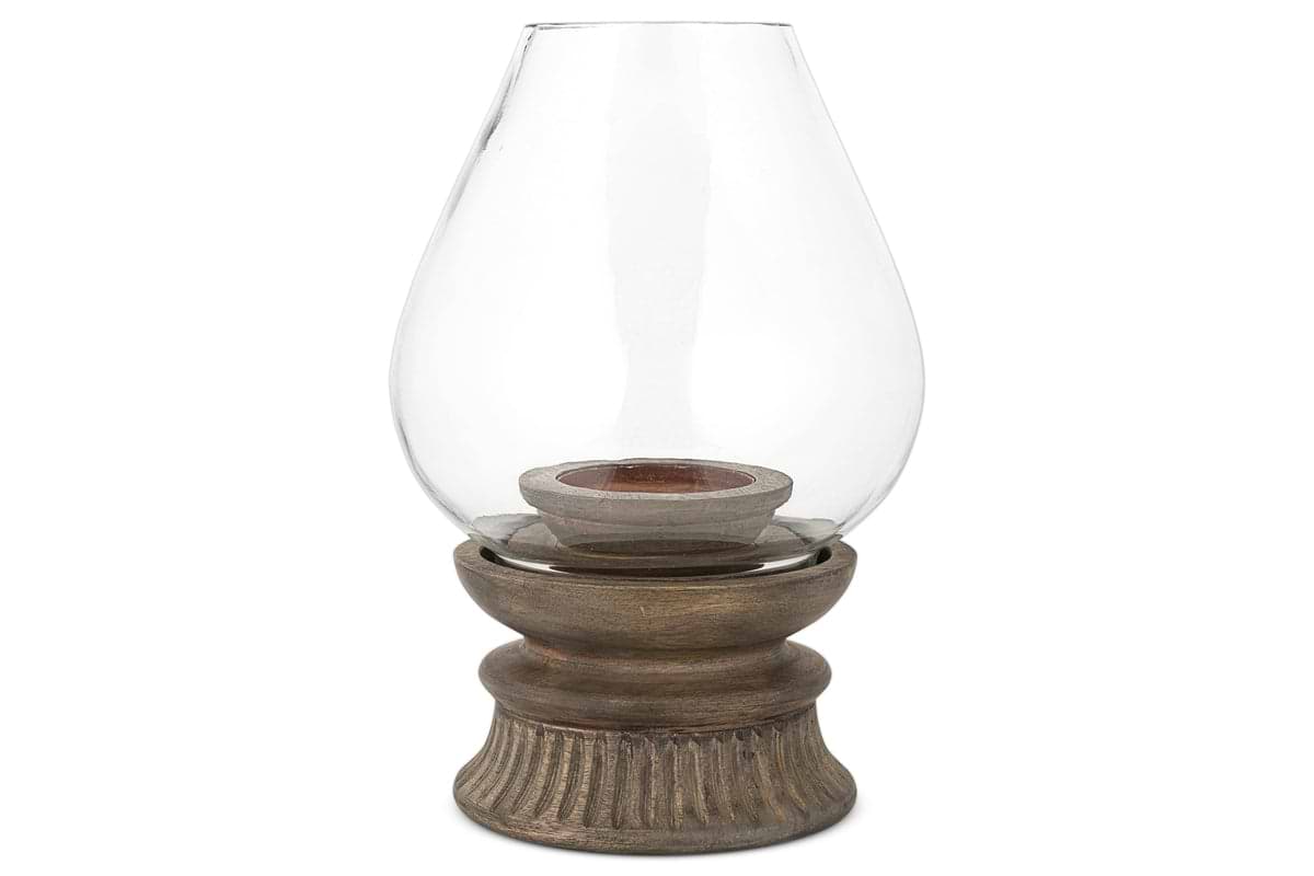 The nkuku Kawani Mango Wood Lantern in Dark Ash features a glass vase on a mango wood stand, ideal for displaying rustic pillar candles.