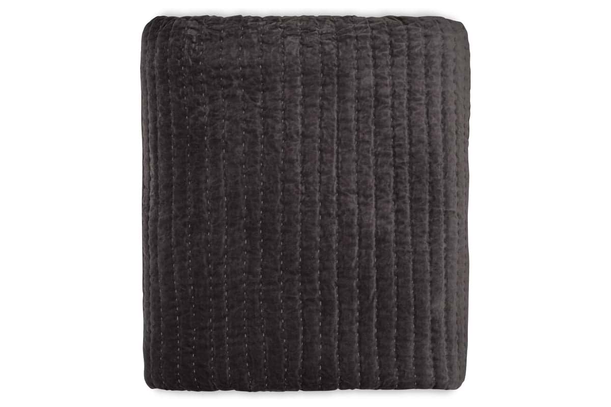 The Nidra Velvet & Linen Bed Quilt - Charcoal by nkuku is a folded, dark gray cotton velvet and linen quilt with vertical Kantha stitching, shown against a white background. Suitable for King and Super King beds.