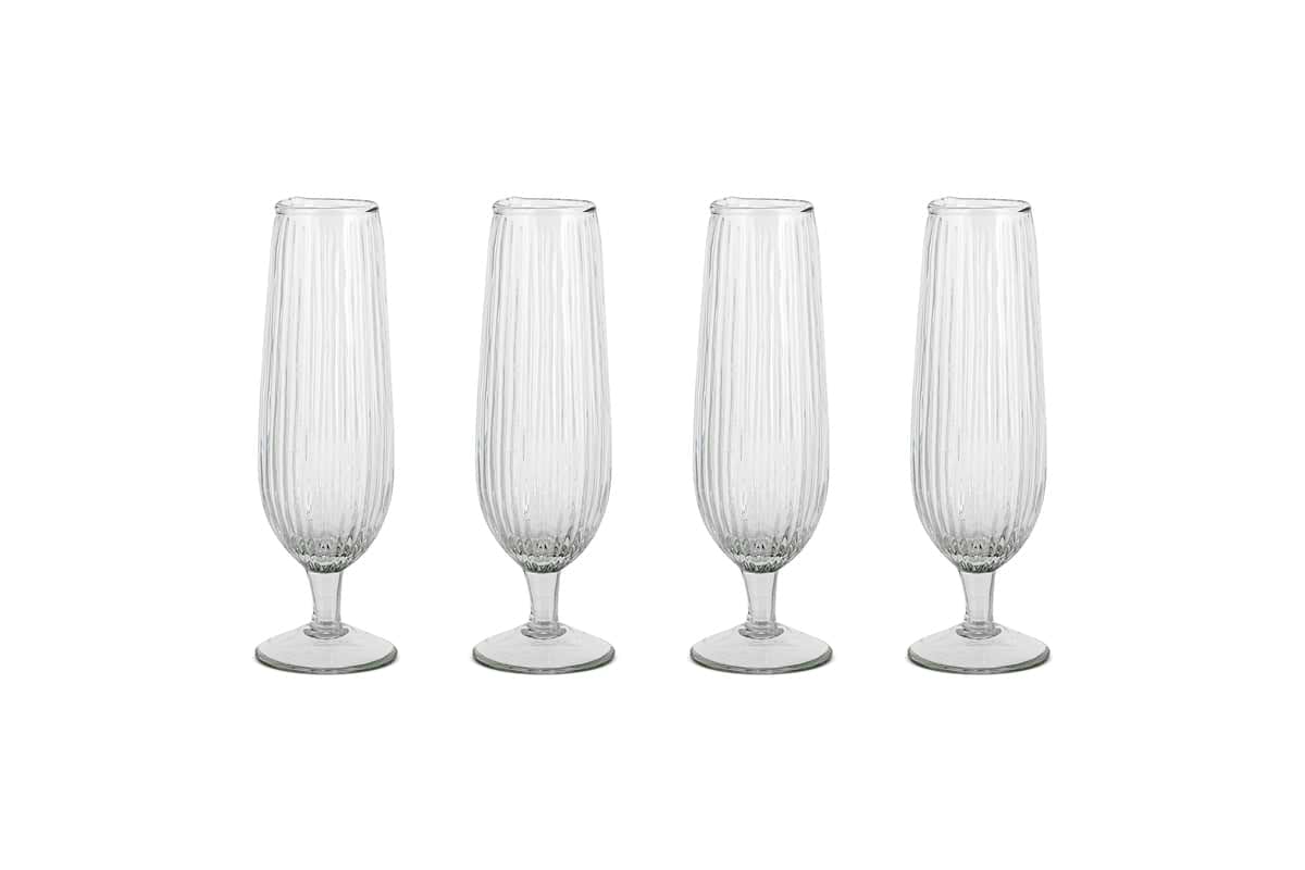 The Otuba Champagne Flute - Clear (Set of 4) by nkuku features four ribbed, recycled glass flutes arranged in a row on a white background.