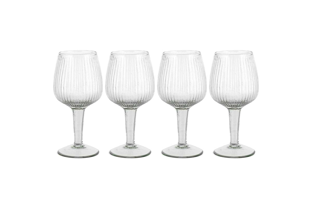 The Otuba Wine Glass - Clear (Set of 4) from nkuku features four recycled glass wine glasses with vertical ribbing, displayed in a row against a white background.