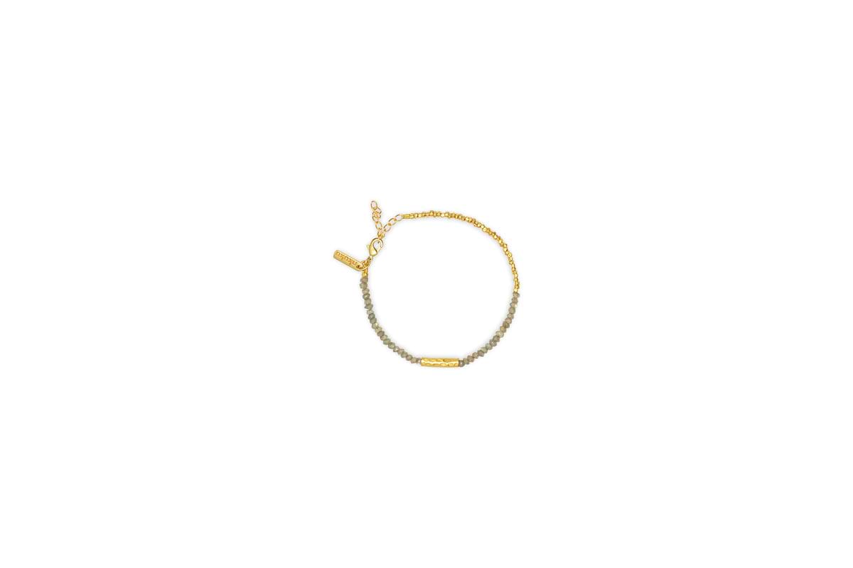 The Perdu Labradorite Bracelet - Gold by nkuku features small gray labradorite and gold brass beads, a gold bar centerpiece, and an adjustable clasp for a refined touch of natural stone elegance.