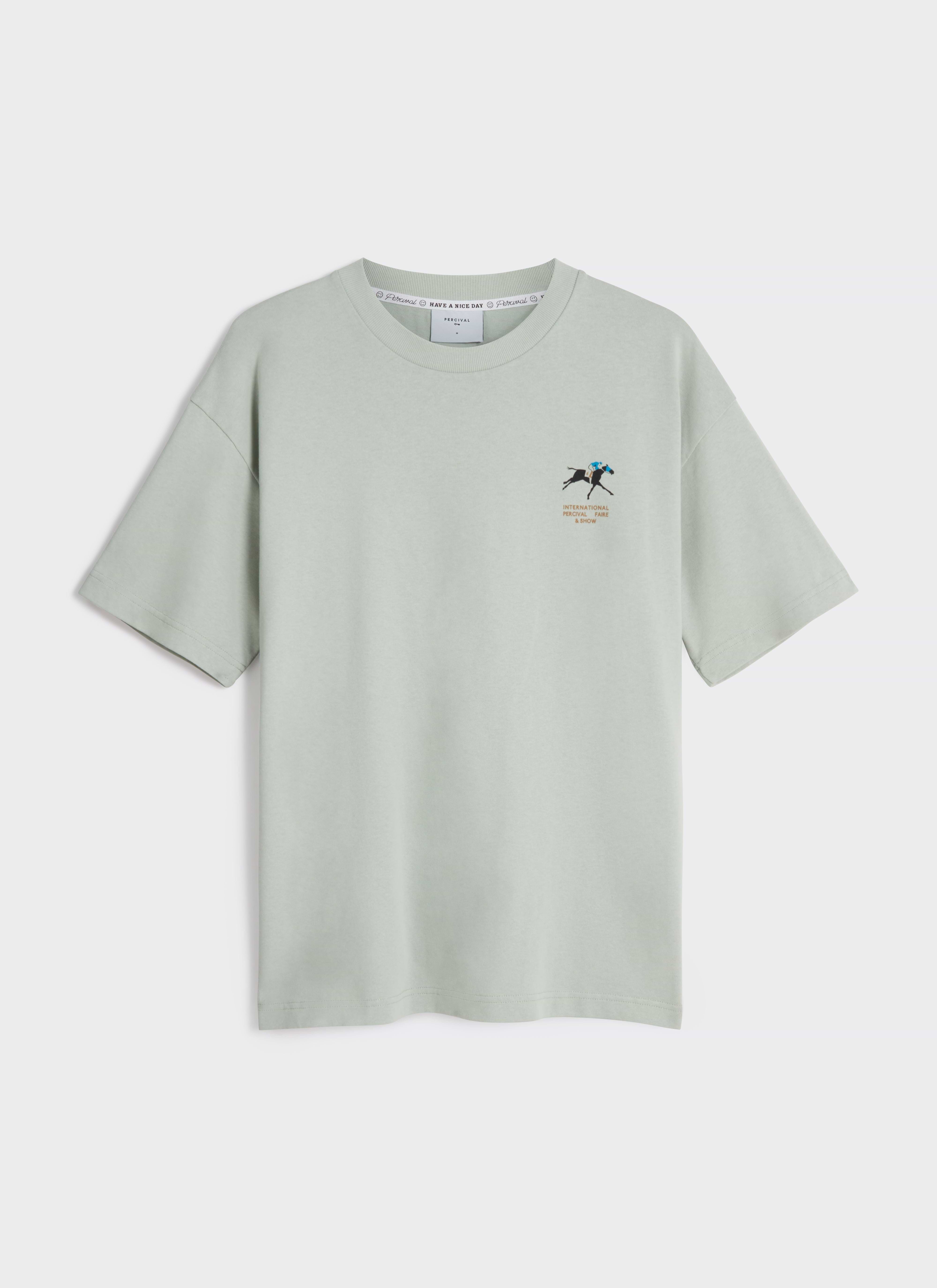 A flat lay of the Percival Fair and Show Oversized T Shirt in sage green, featuring the horse and jockey chest graphic.