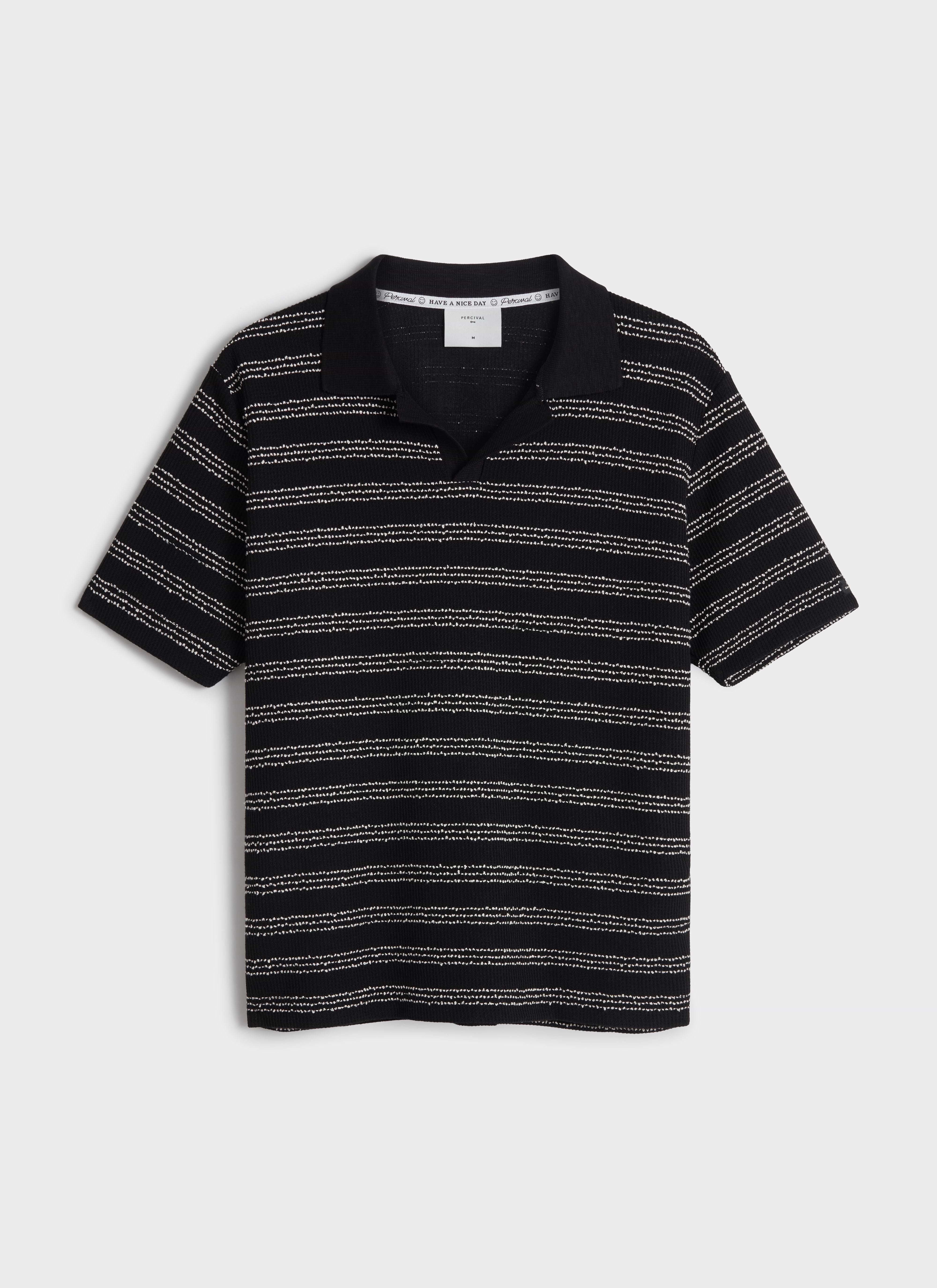 A flat lay of the Percival Laurent Boxy Polo in black with horizontal textured stripes and an open collar.