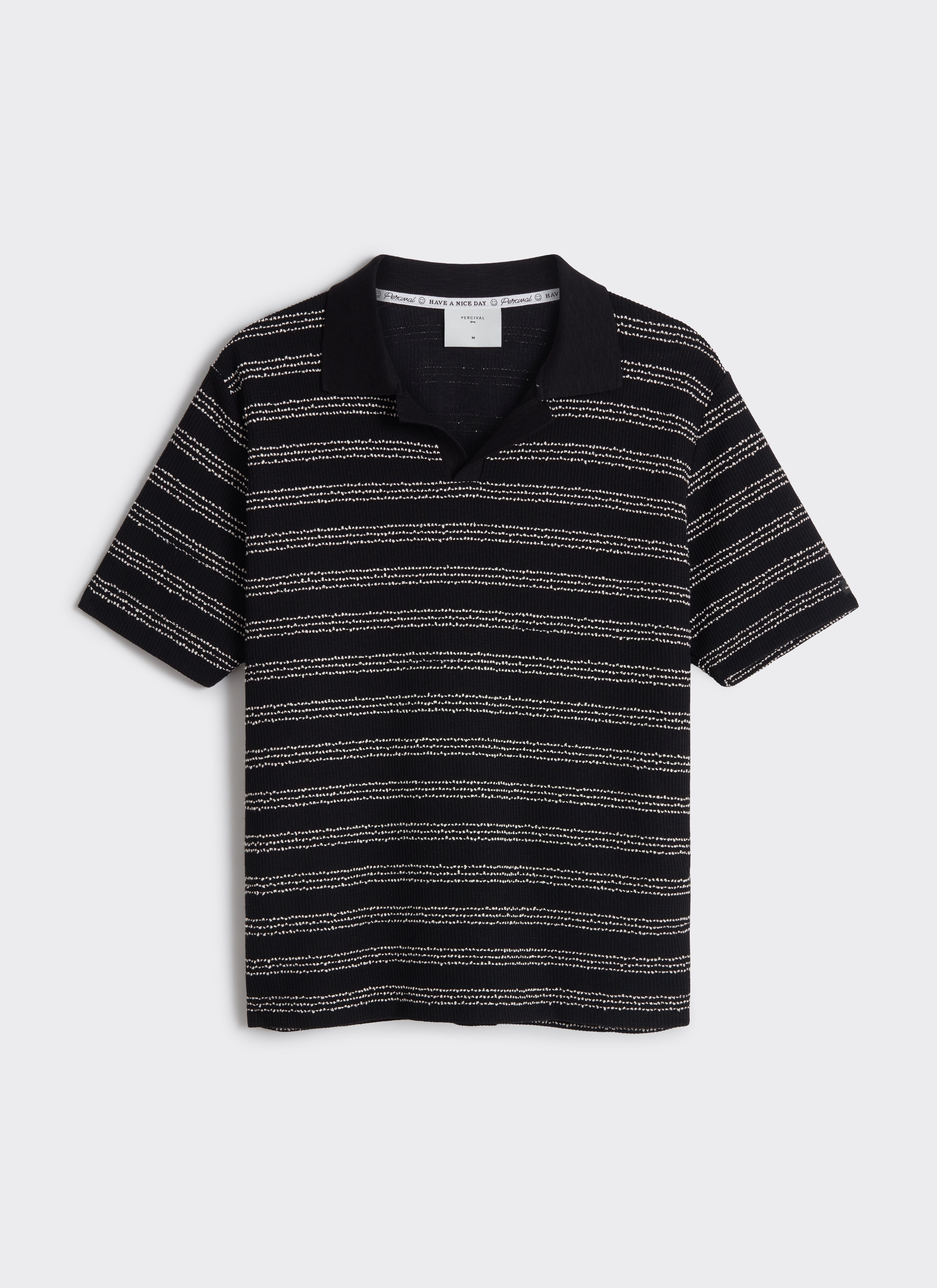 A flat lay of the Percival Laurent Boxy Polo in black with horizontal textured stripes and an open collar.