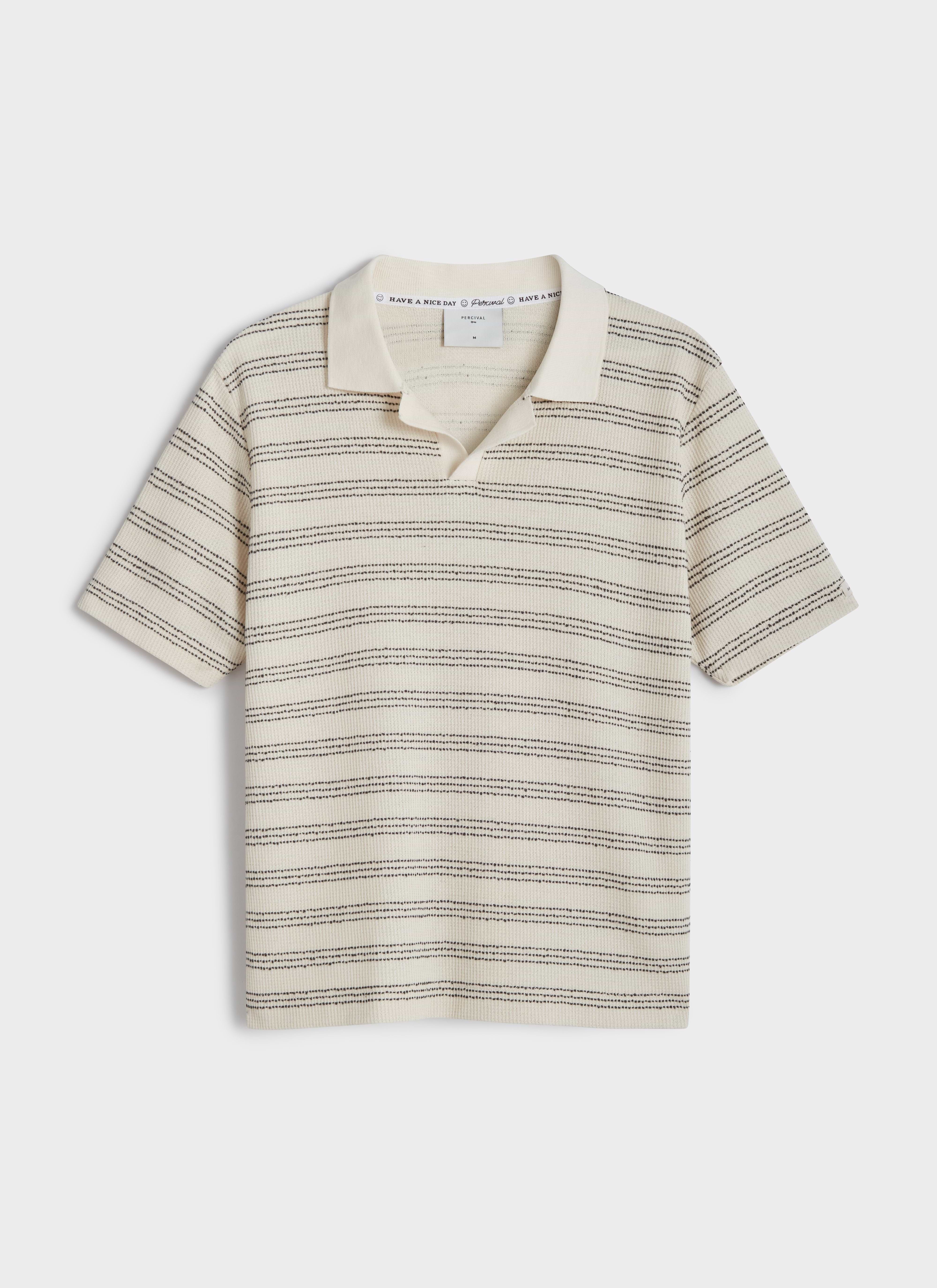 A flat lay of the Percival Laurent Polo in cream, featuring a horizontal black stripe cotton knit and an open collar.