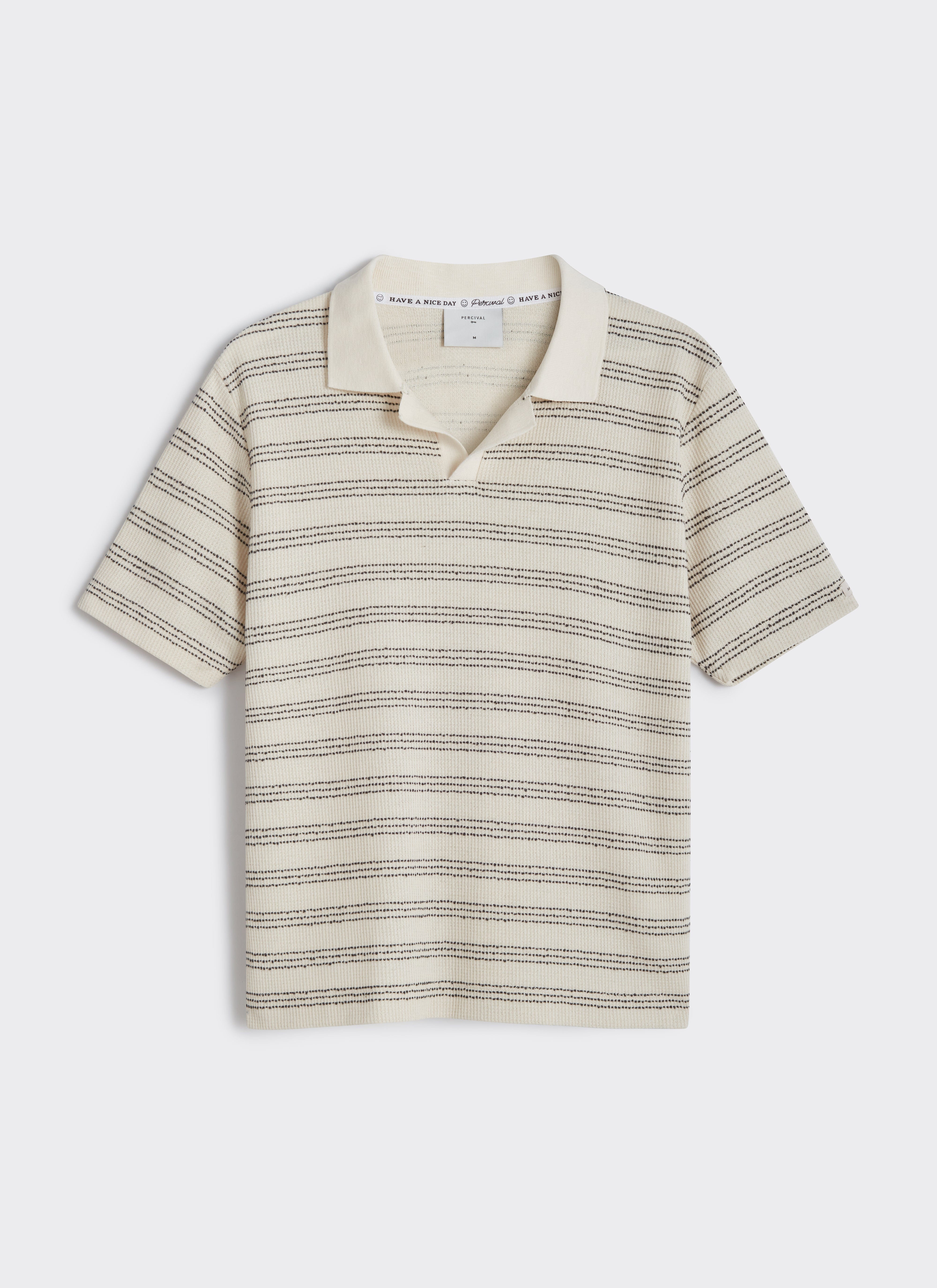 A flat lay of the Percival Laurent Polo in cream, featuring a horizontal black stripe cotton knit and an open collar.
