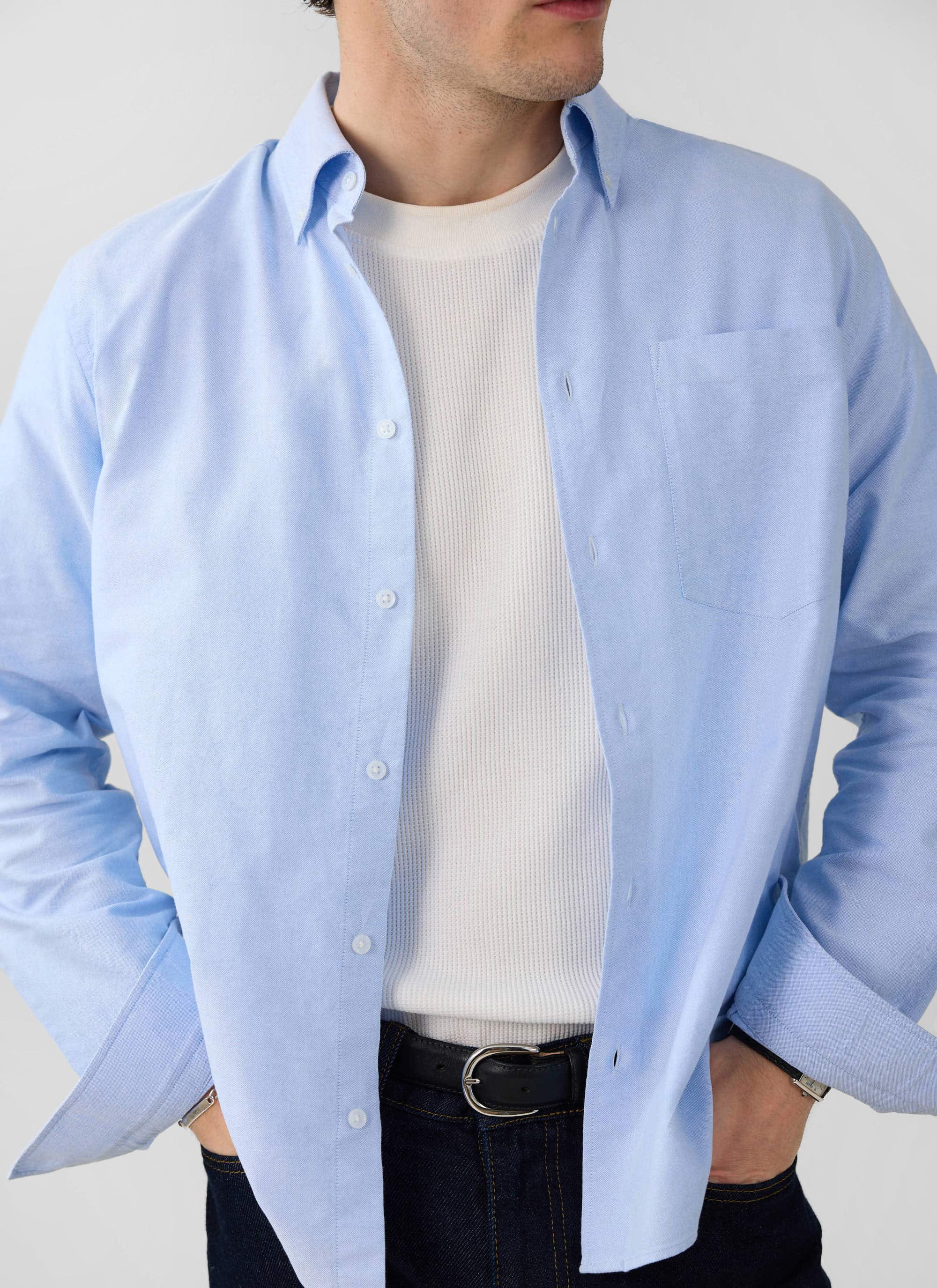 A model styles the Percival white Waffle Short Sleeve T-Shirt under an open light blue shirt with dark denim jeans.