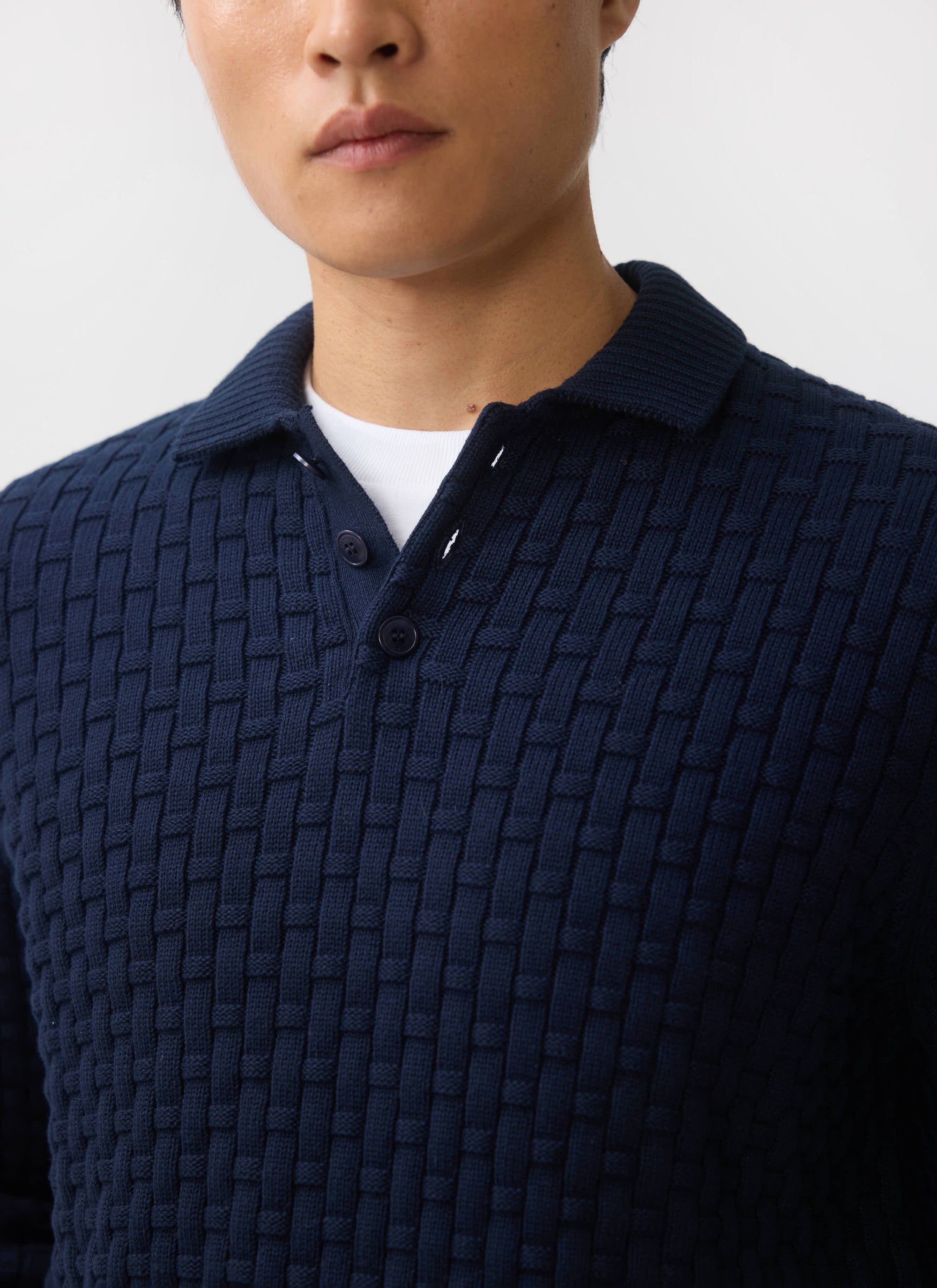 A close-up of a model wearing the navy Percival Archer Basketweave Knitted Shirt, showing the textured knit.