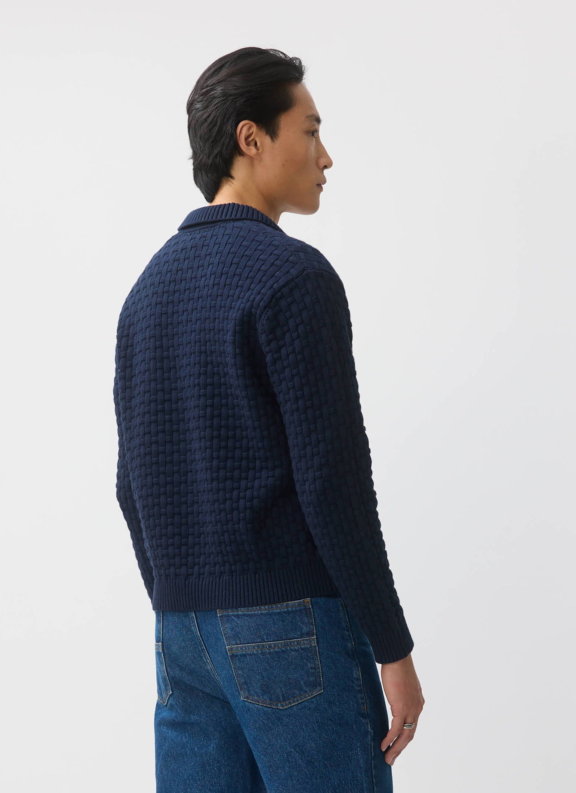 The back of a model wearing the navy Percival Archer long sleeve knitted shirt, showing off the unique basketweave texture.
