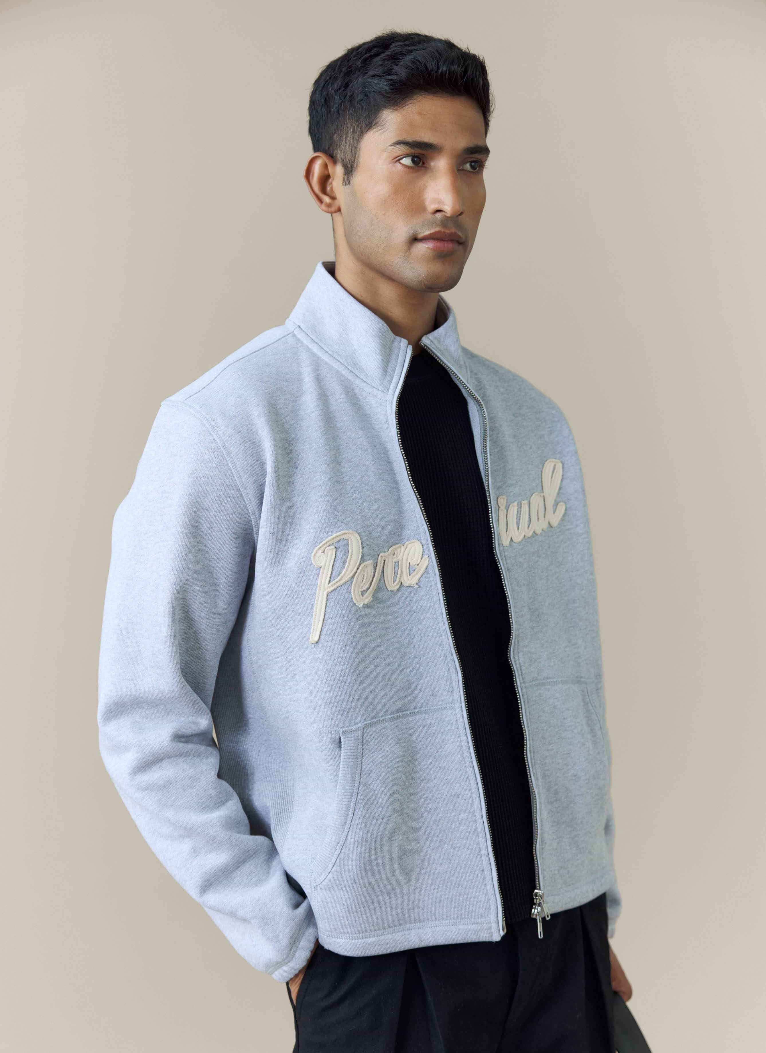 A model wears the Percival Curtis Boxy Zip Funnel Neck Sweatshirt in athletic grey, showing the cream script logo embroidery.