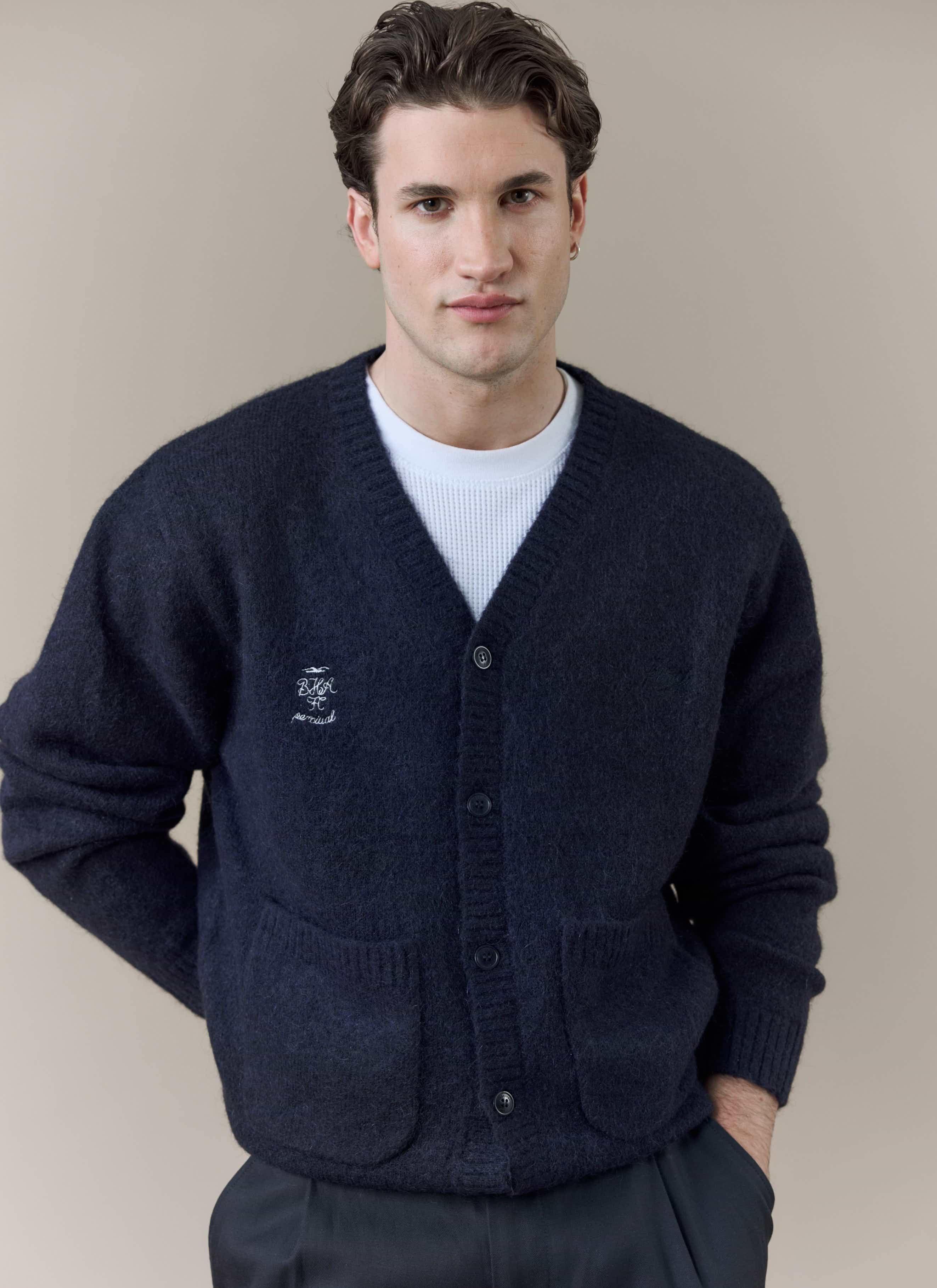 A model wears the navy wool-blend White Glove Cardigan from the Percival x Brighton & Hove Albion F.C. collaboration.