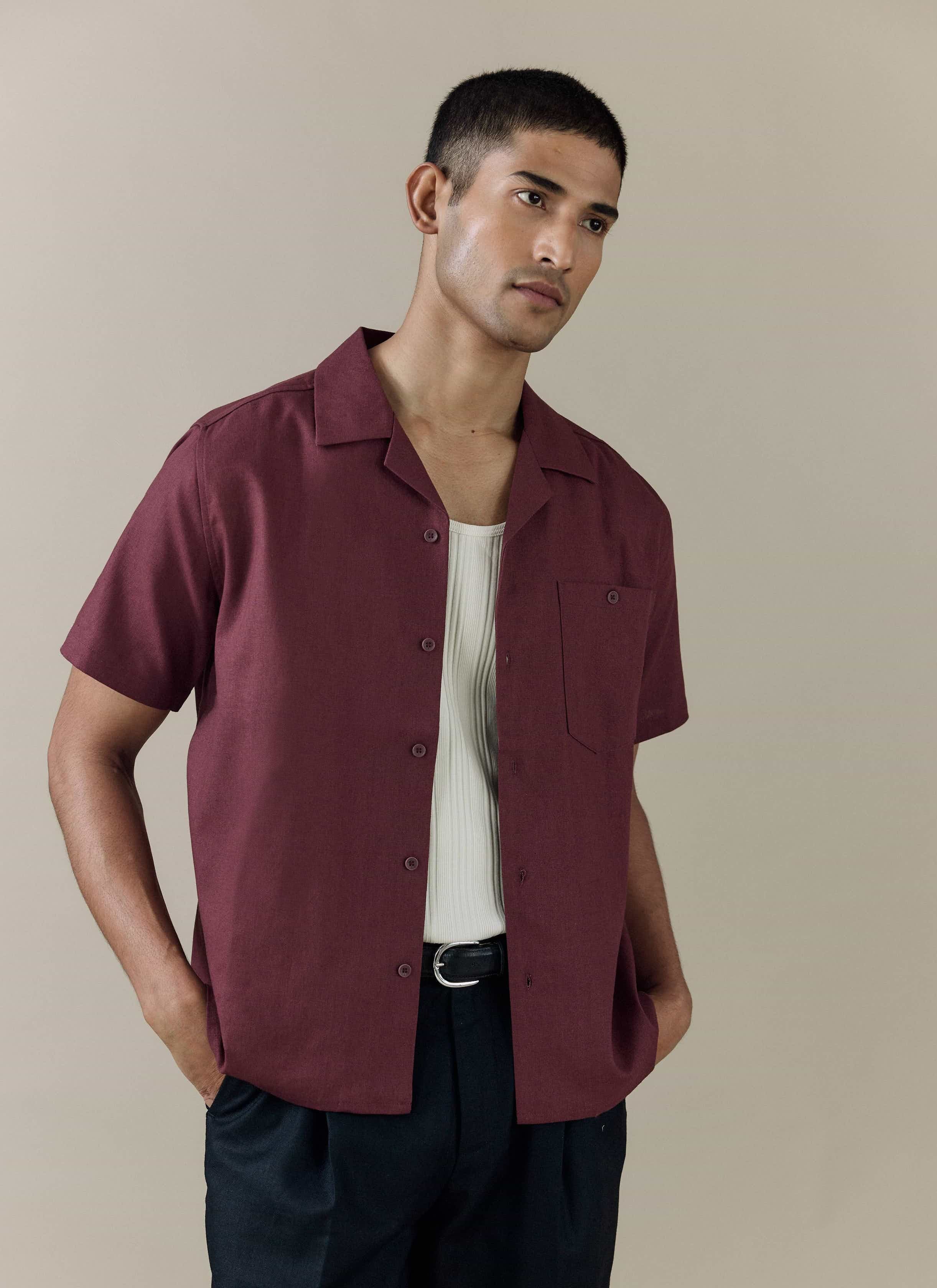 Percival Short Sleeve Cuban Shirt in Merlot linen blend, styled open over a white rib vest and dark pleated trousers.