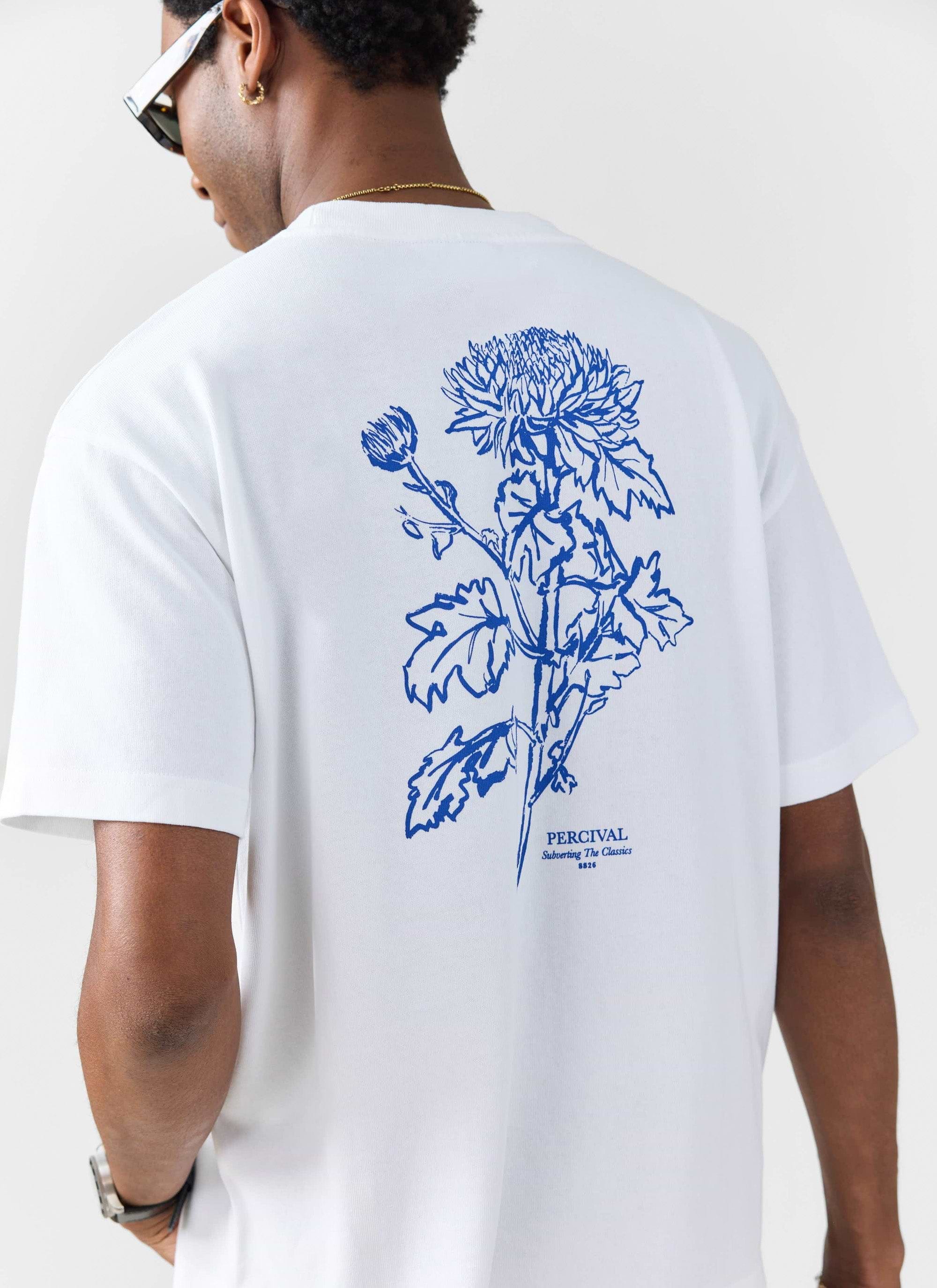 A man models the back of the white Smith Floral oversized t-shirt from Percival, showing the blue floral illustration.
