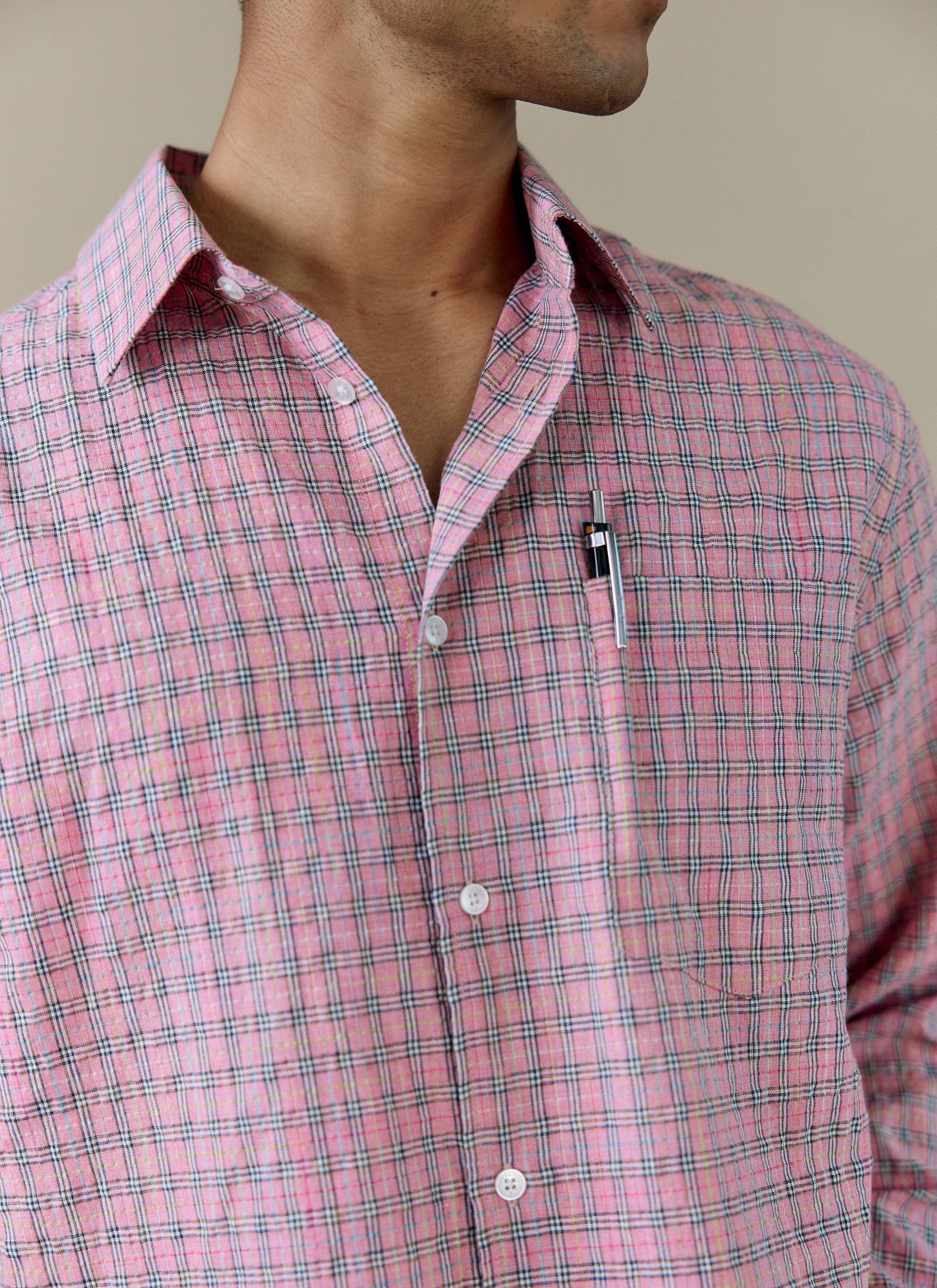 A close-up of the Percival Hinsley Checked Boxy Shirt in pink, showing the cotton check pattern and chest pocket detail.