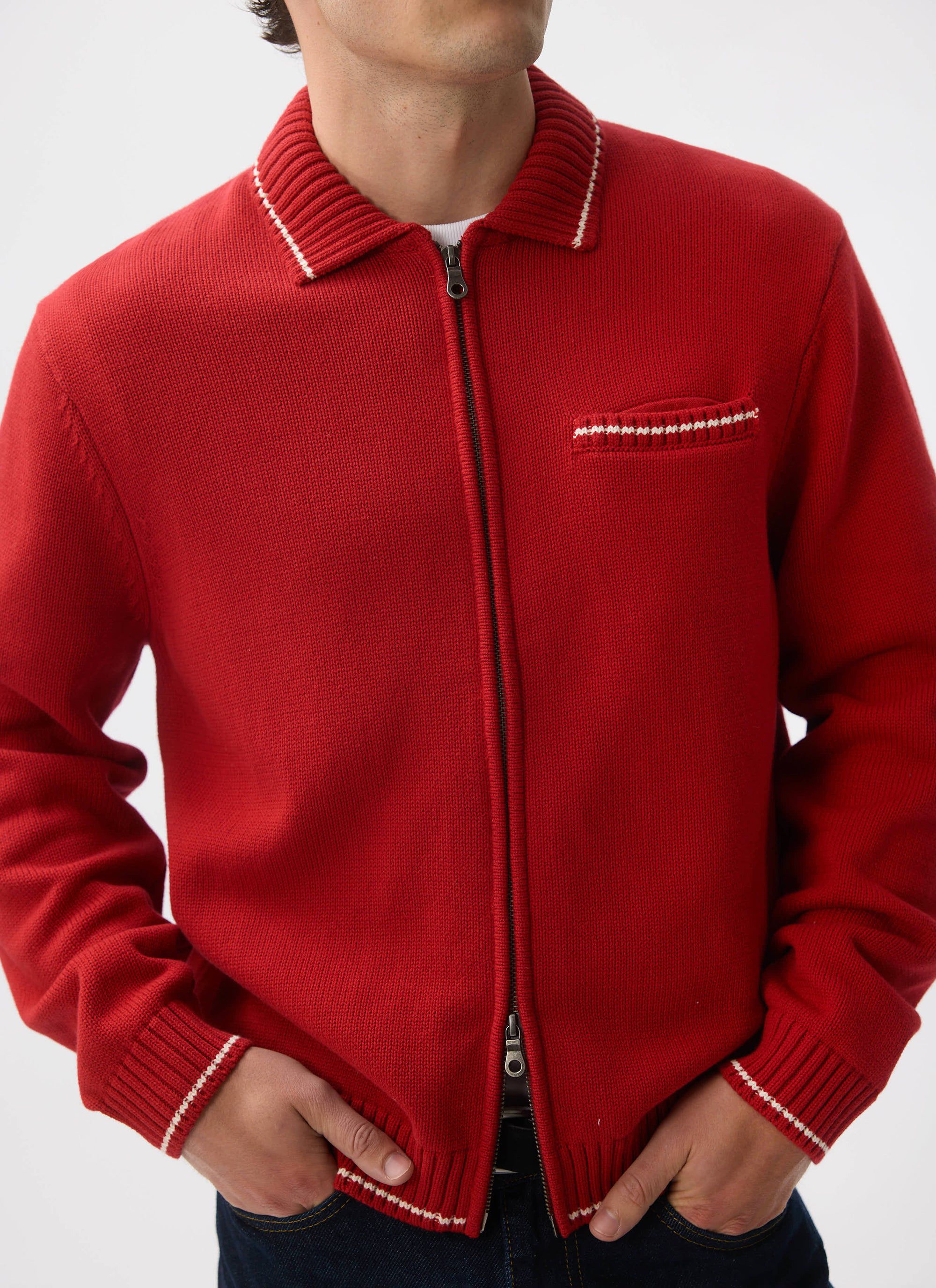 Close-up of a model wearing the Percival Gardner Knitted Zip Cardigan in red, highlighting the contrast stitch detail.