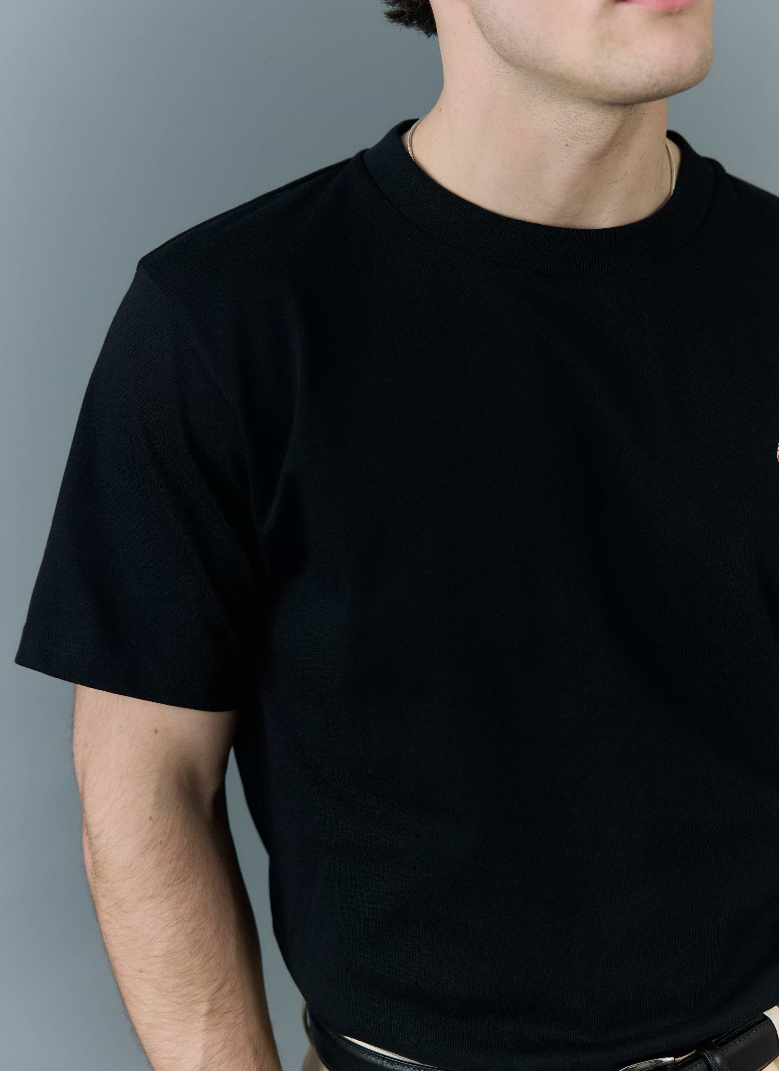A close-up of a model wearing the Percival regular fit t-shirt in black organic cotton.