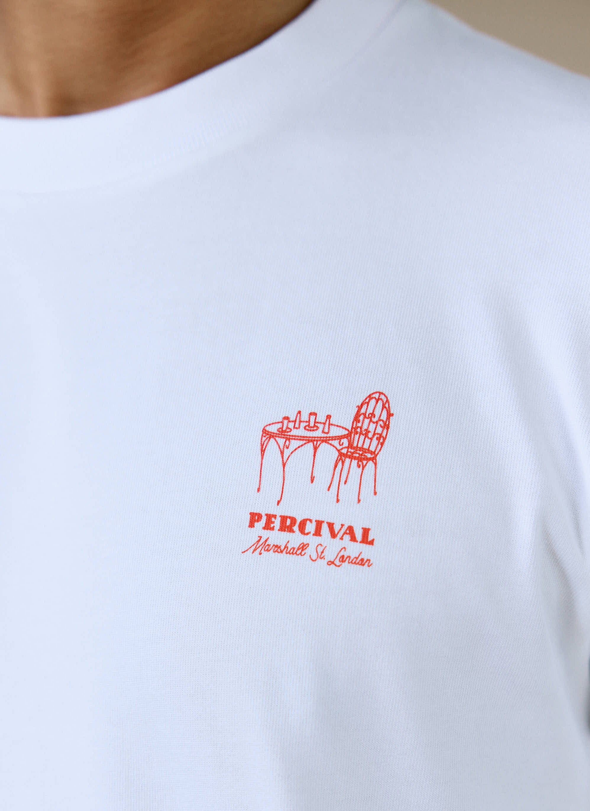 Close-up of the red bar-table chest graphic on the white organic cotton Perci Fine Wines T Shirt from Percival.
