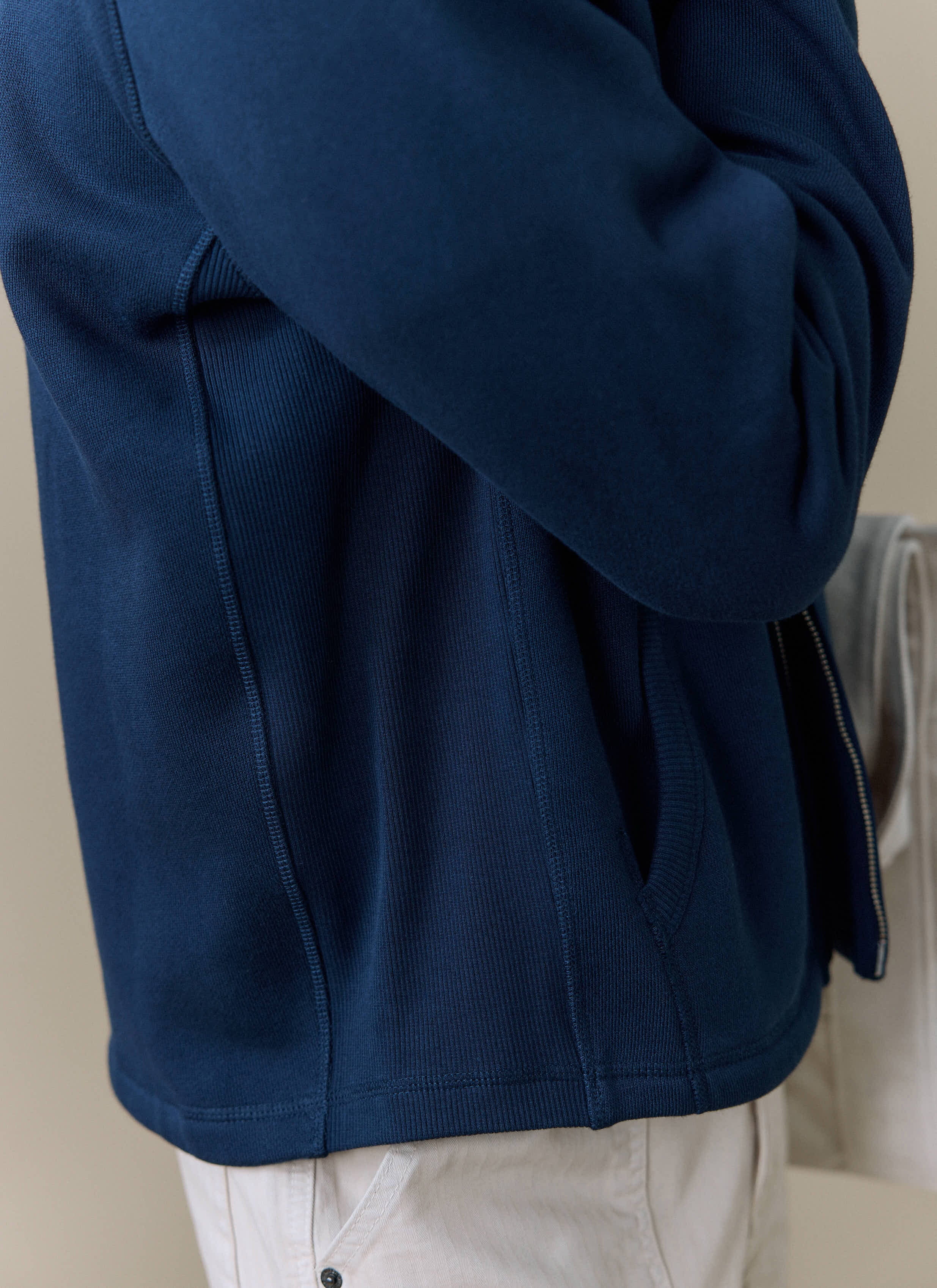 Close-up of a model wearing the navy Curtis Boxy Zip Harrington from Percival, showing the side pocket and ribbed cotton.