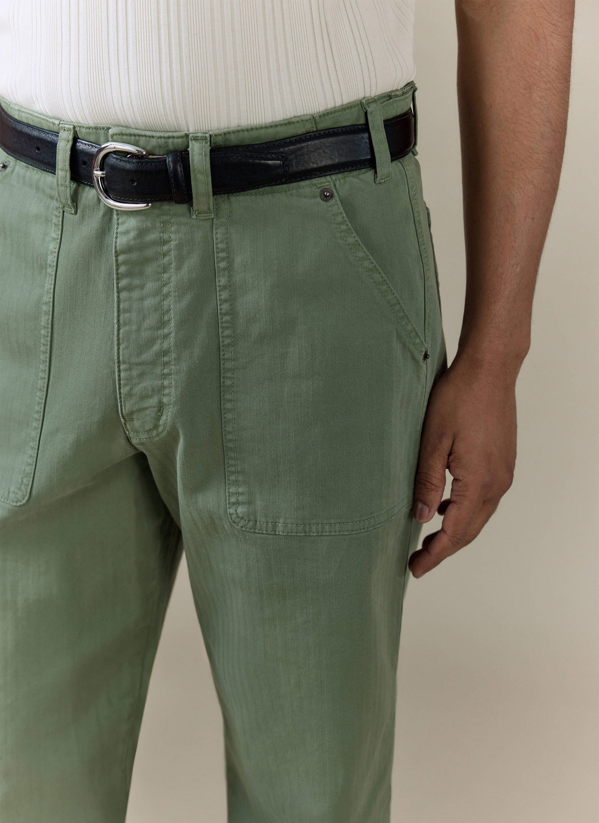 Percival Lungo Herringbone Straight Trousers in sage green cotton, featuring front patch pockets and a black leather belt.